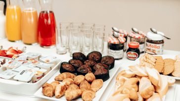 An enticing breakfast buffet with croissants, muffins, bread, juices, and spreads, perfect for a refreshing start to the day.