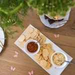 Top-down view of a table with assorted crackers, dips, and finger foods elegantly arranged.