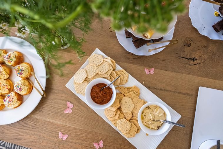 Top-down view of a table with assorted crackers, dips, and finger foods elegantly arranged.