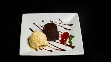 Indulge in rich chocolate lava cake with smooth ice cream and cherries.