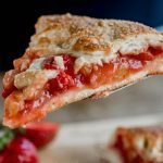 Delicious close-up of a freshly baked strawberry rhubarb pie slice on a spatula.
