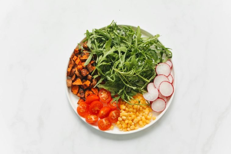 Colorful and healthy salad with mixed vegetables on a white background.