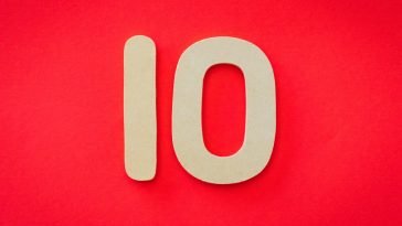 Wooden number 10 on a vibrant red background, ideal for educational and creative projects.