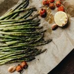 Delicious grilled asparagus with roasted cherry tomatoes and lemon, perfect for a healthy meal.