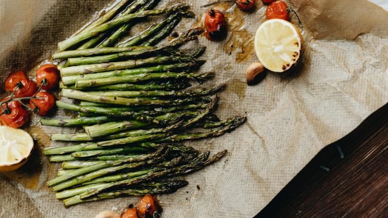 Delicious grilled asparagus with roasted cherry tomatoes and lemon, perfect for a healthy meal.