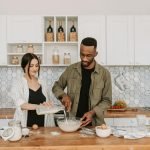 A couple collaboratively prepares a meal in a stylish contemporary kitchen setting.