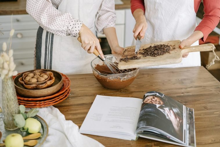 Two people preparing chocolate dessert with ingredients in a cozy kitchen setting.