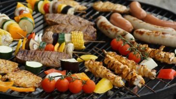 A vibrant assortment of grilled meats, sausages, and vegetables on a barbecue grill.