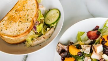 Fresh toasted sandwich with lettuce, cucumber, and a vibrant chicken salad on the side.