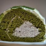 Delicious matcha Swiss roll cake with creamy filling in a close-up view.