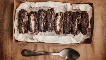Close-up of rich chocolate brownies in a box on a rustic surface. Perfect for dessert lovers.