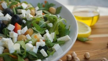 A colorful Mediterranean salad featuring feta, olives, chickpeas, and fresh greens.