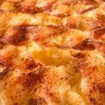 Delicious close-up of grilled mashed potato topping with golden brown crust and spices.