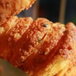 Detailed close-up of a flaky, golden-brown croissant with a crispy texture.