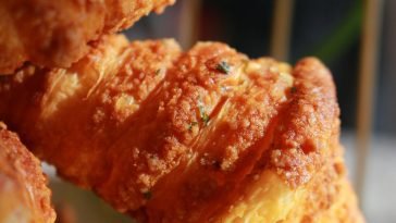 Detailed close-up of a flaky, golden-brown croissant with a crispy texture.