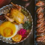 A gourmet Persian meal featuring roast chicken, saffron rice, and assorted sides. Ideal for foodies.