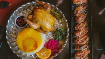 A gourmet Persian meal featuring roast chicken, saffron rice, and assorted sides. Ideal for foodies.