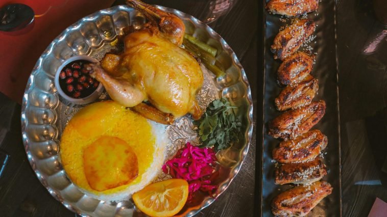 A gourmet Persian meal featuring roast chicken, saffron rice, and assorted sides. Ideal for foodies.