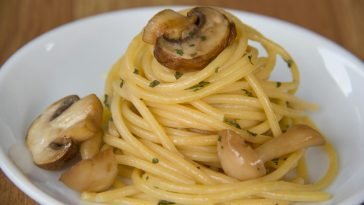 Appetizing mushroom pasta on a white plate, featuring a close-up view of the culinary delight.