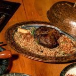 Delicious roasted lamb with fragrant rice served in a copper platter.