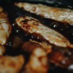 Delicious marinated chicken pieces sizzling in a pan, perfect for a hearty meal.