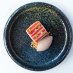 Top view of a gourmet rhubarb dessert with ice cream on a beautiful ceramic plate.