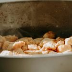 A close-up view of tofu cubes being cooked in a frying pan.