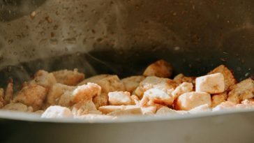 A close-up view of tofu cubes being cooked in a frying pan.