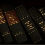 Stack of legal and literature books in a library showcasing various volumes.